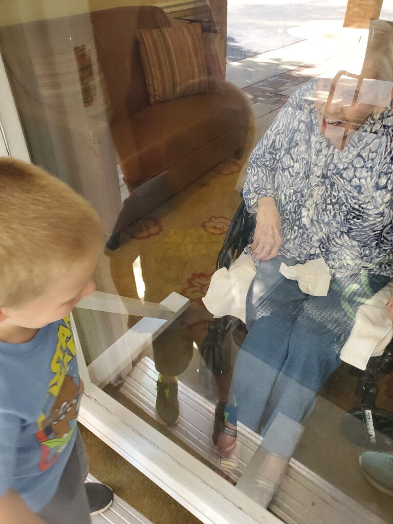 Visiting grandparents behind plexiglass during the pandemic